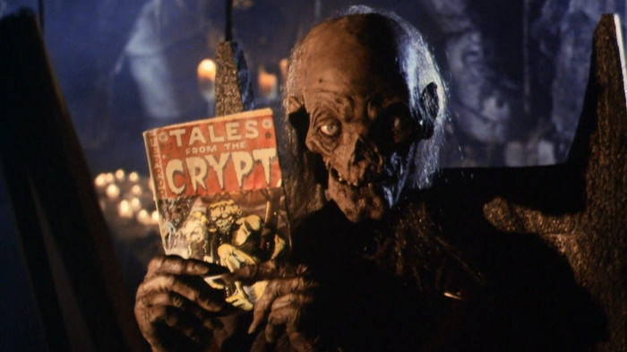 The Crypt Keeper holding up a Tales from the Crypt comic